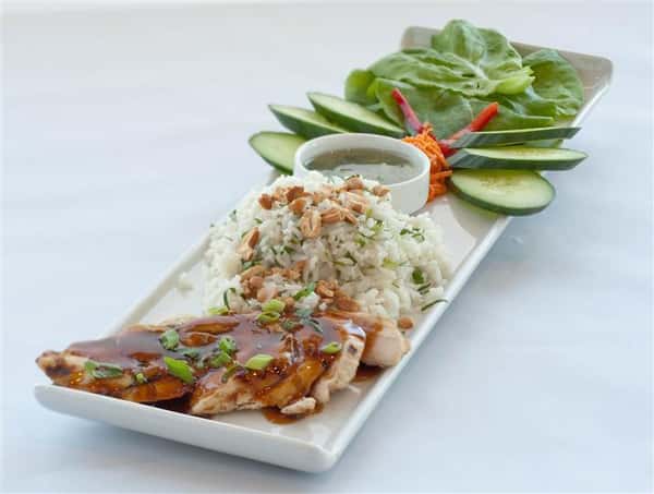 Chicken teriyaki served along with rice and sliced vegetables