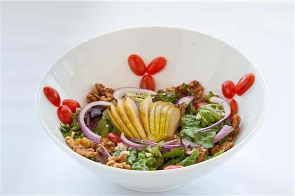 Salad consisting of evenly sliced lemons, lettuce, pecans, and sliced onions