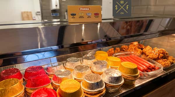 Selection of Pukka pies and other freshly prepared takeaway food displayed behind the counter.