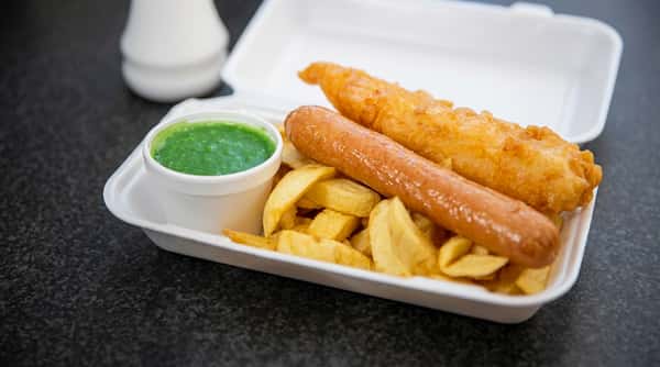 Battered fish and sausage served with chunky chips and a pot of mushy peas.