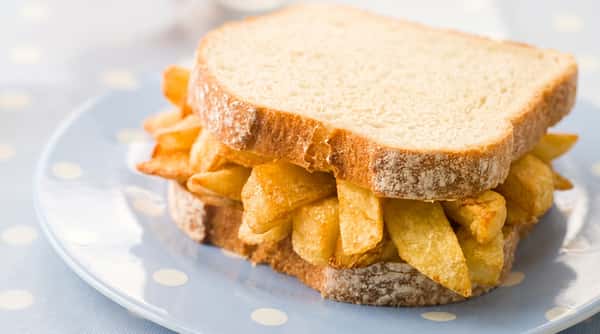 Chunky chip-shop chips served inside a soft, sliced bread sandwich.