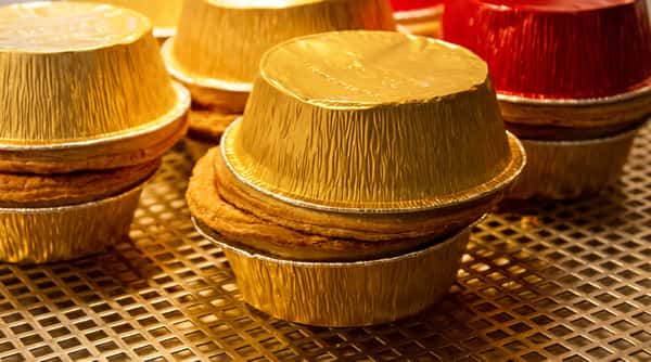 Traditional individual pies in foil cases displayed fresh and ready to serve.