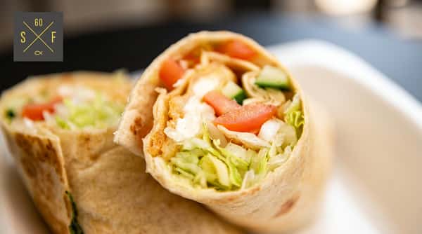 Fish wrap filled with fresh lettuce, tomato, cucumber and onion, ready to enjoy.
