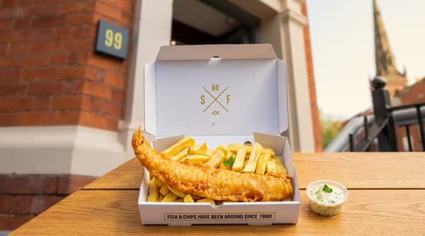 Traditional battered fish and chunky chips served in a Sixty Fish takeaway box.
