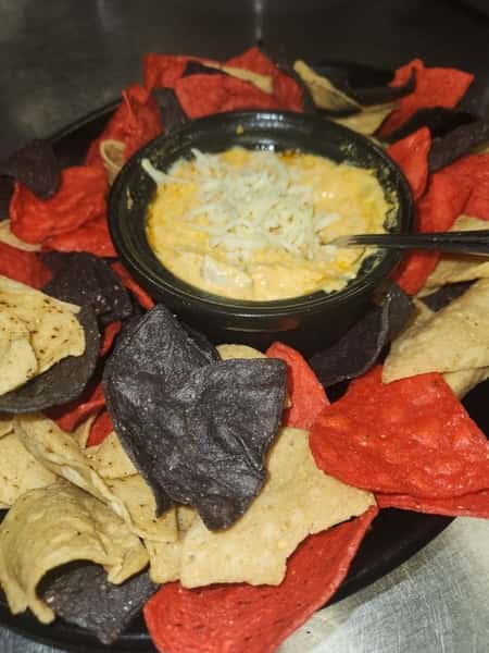 Tri-color tortilla chips served with a cheesy buffalo chicken dip topped with shredded cheese.
