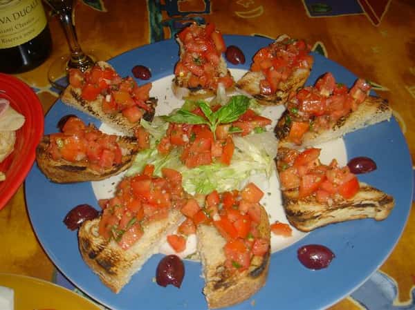 toasted bread topped with tomatoes on a plate