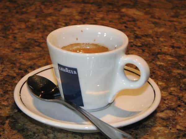 coffee mug with coffee and a spoon next to it