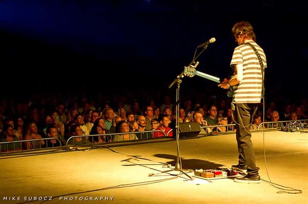 man with guitar performing on stage