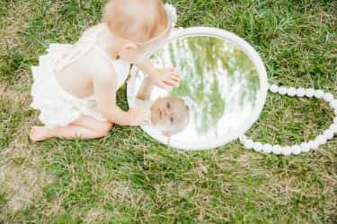 Baby in mirror under willow tree