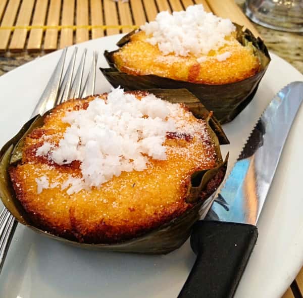 A traditional Filipino bibingka rice cake, baked until golden and topped with grated coconut, served warm on a plate.