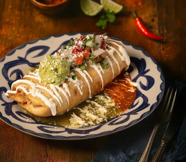 crispy rolled tacos topped with crema, cheese, and herbs on a decorative plate