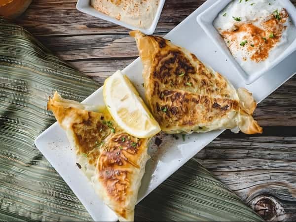 Crispy stuffed pastry served with lemon and creamy dipping sauce.