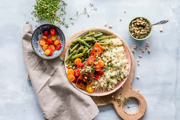 Mediterranean grain bowl with rice, green beans, roasted tomatoes, and fresh herbs.