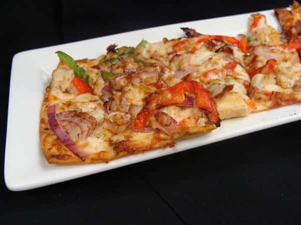 Pizza with chicken, red onions, and peppers