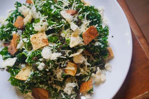 Fresh kale Caesar salad with shredded parmesan, croutons, and creamy dressing, ideal for healthy lunch or side dish options.