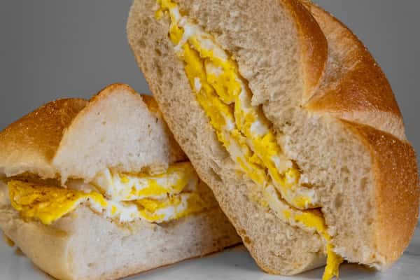 Scrambled eggs cooked on a grill served on a roll