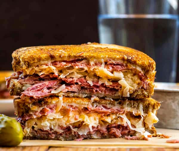 Corned beef on rye bread with sauerkraut Russian dressing melted Swiss cheese