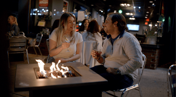 Couple sitting outside by a firepit
