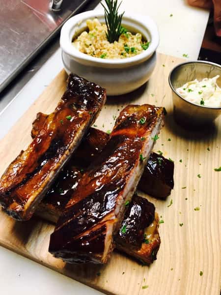 BBQ spare ribs stacked up on a wood board