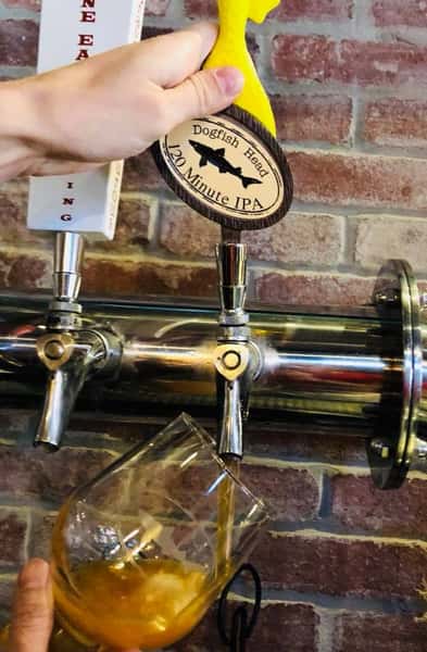 Dogfish head 120 Minute IPA being poured out of a beer tab into a glass