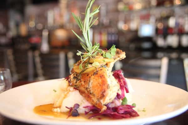 Roasted chicken over mashed potates and red onions with rosemary
