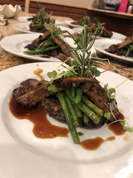 asparagus and three ribs covered in sauce on a plate