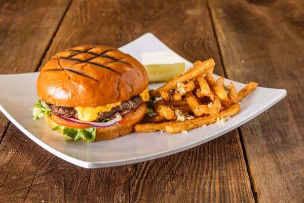 Grilled cheeseburger with melted cheddar, lettuce, tomato, and red onion on a toasted brioche bun served with seasoned French fries.
