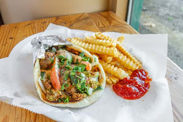 Your tastebuds called, they're craving a Falafel Wrap from Baba Ghannouj! Topped with fresh Tomato, Onion, Cucumber, Pickles, Parsley & Tahini Sauce - it's no wonder this dish is a fan favorite. You gotta try it to believe it. #FalafelWrapLove #BabaGhannoujDelights 🌯😍