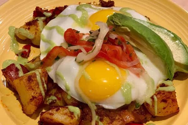 fresh breakfast plate with eggs, golden potatoes and avocado