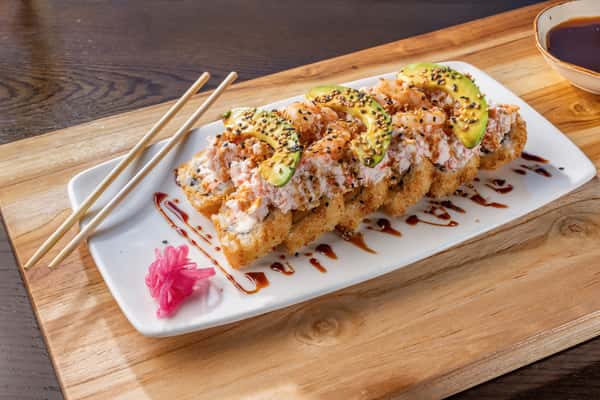 Guamuchilito sushi roll topped with crab mix and avocado slices