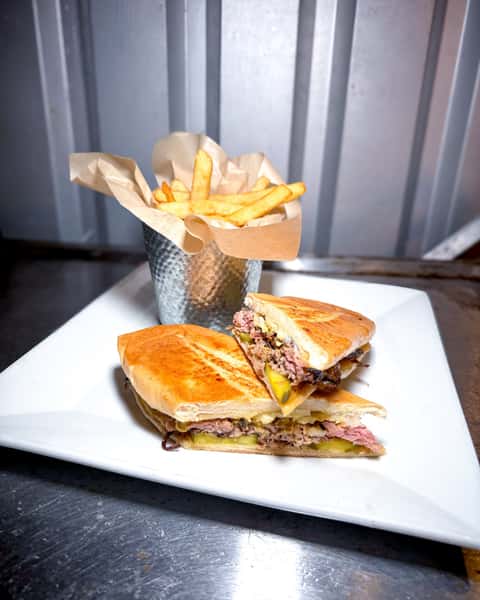 It's easy to see why Double S Cuban is one of the most talked-about picks at Double S Smokehouse 🥪 Seasoned pulled pork, swiss cheese, pickles, and spicy mustard pressed on a panini create that bold, balanced bite people keep coming back for, and it's served with 1 side. 🔥 #DoubleSSmokehouse #DoubleSCuban #GuestFavorite #SmokehouseCravings