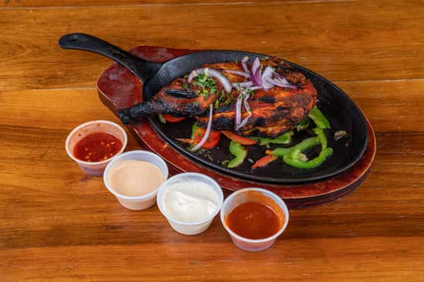 Grilled half chicken with peppers and onions served sizzling with house sauces.