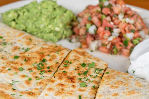 Grilled quesadilla served with guacamole, pico de gallo, and sour cream at Nara Cafe.