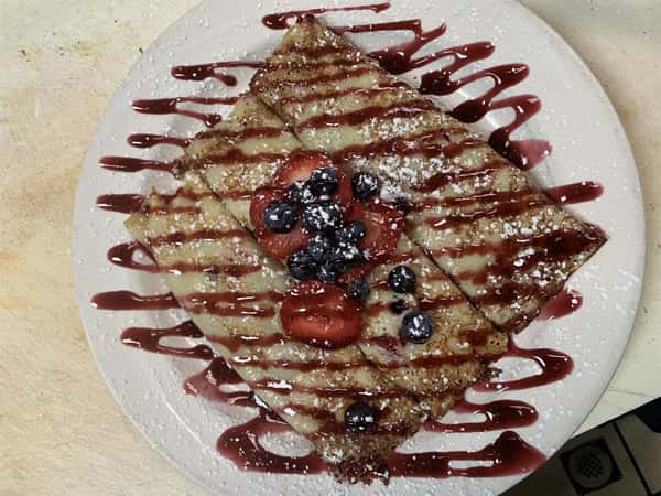 Very Berry Crepes stuffed with with fresh strawberries, blueberries, sweet cream cheese then topped with powdered sugar and melba sauce