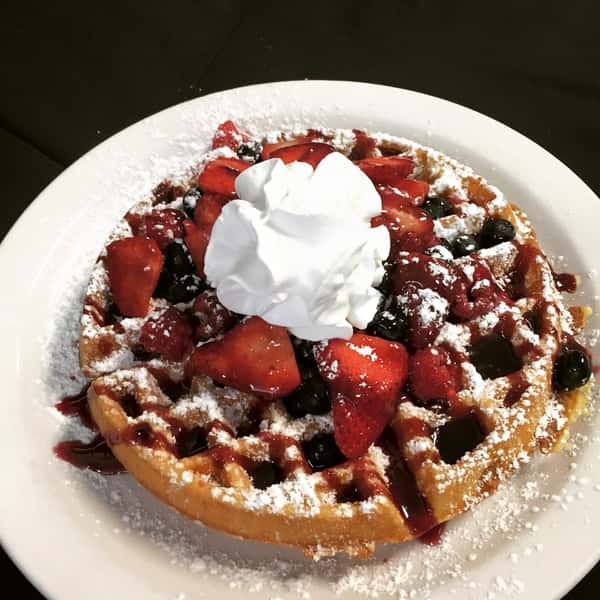 French toast topped with strawberries, powdered sugar, whipped cream