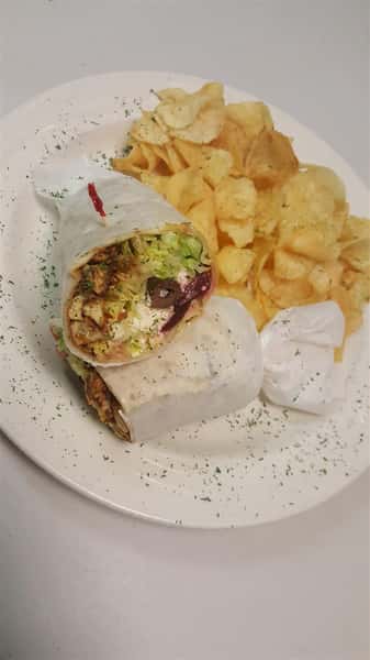 Greek Chicken wrap stuffed with chopped lettuce, tomato, olives, peppers, chicken, feta cheese, beets and Greek dressing