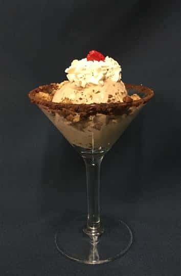 Chocolate ice cream topped with cream and a cherry