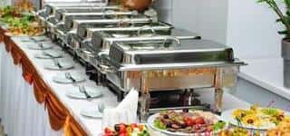 A buffet with trays of hot dishes