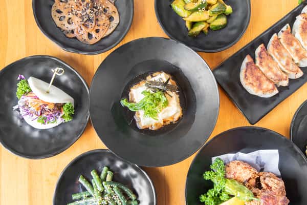 A variety of side dishes from Moto Ramen spread out on a table