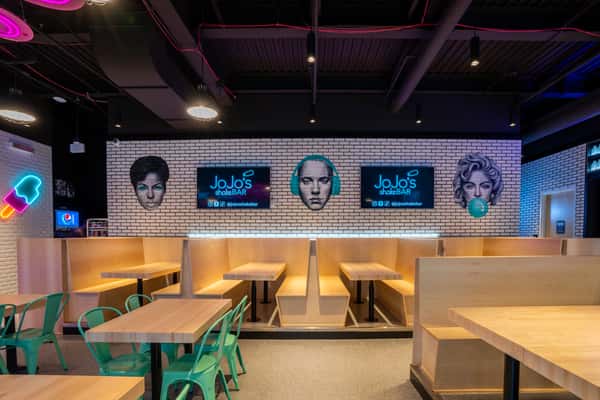 Wall art in JoJo's Detroit of iconic faces from the 80s and 90s - Madonna, Eminem, and Aretha Franklin