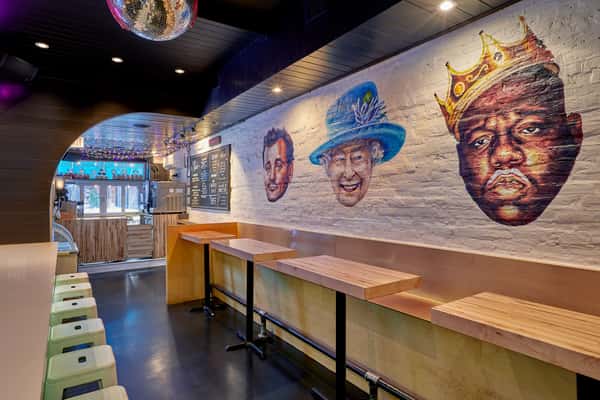 Faces on the wall of JoJo's shakeBAR of Bill Murray, Queen Elizabeth, and Biggie Smalls with milk mustaches