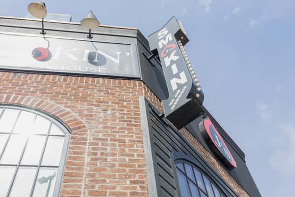 Smokin' brick exterior with bold signage on a brew house restaurant building under blue sky