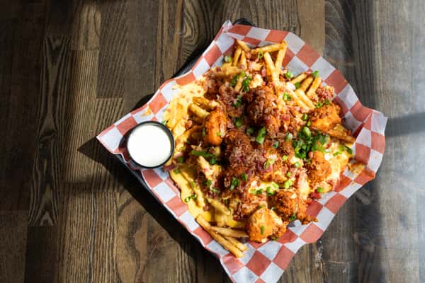 Loaded fries topped with melted cheese, buffalo chicken, bacon, and green onions served with ranch dressing