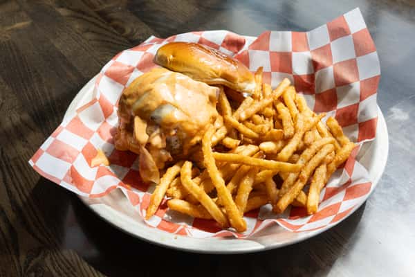 cheeseburger with melted cheese and sauce served with crispy French fries on a checkered liner