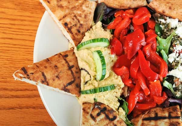 Pita bread triangles with hummus and red peppers