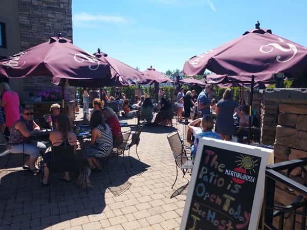 Outdoor patio with people sitting at tables under umbrellas