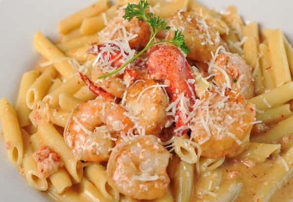 Pasta topped with shrimp, lobster, and shaved parmesan cheese