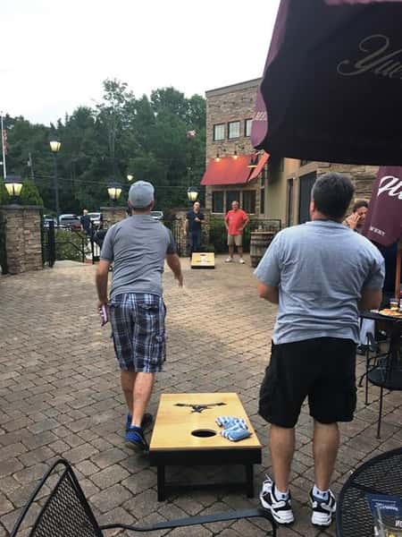 People playing cornhole on outdoor patio