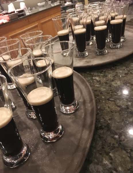Trays of beer glassed half filled with guniness