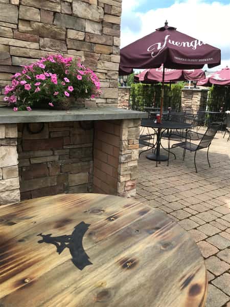 Outdoor patio with wooden table and stone fireplace